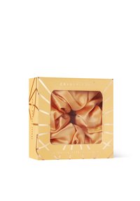 Maulbeerseiden-Haargummis verpackt in einer goldenen Box mit klarem Fenster. Die Haargummis haben eine sanfte Pfirsichfarbe, eine glatte Textur und ein glänzendes Finish.