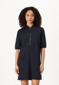 Millitärblaues kurzärmeliges Kleid mit Reißverschlusskragen, ausgestattet mit zwei vorderen Taschen, aus weichem Stoff mit lockerer Passform.