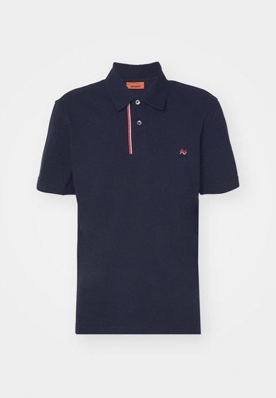 Tumesinine polo särk, mis on valmistatud puuvillast, klassikalise kraega, kolme nööbiga ja punase ja valge aksenttriibuga nööpide piirkonnas. Väike logo rinnal.