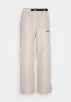 Pantalons légers beige clair, de coupe ample, avec taille élastique, détail ceinturé, poches latérales et logo sur la cuisse gauche. Fabriqués dans un tissu doux.