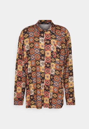 Camisa de manga larga con botones y un patrón de patchwork geométrico colorido en tonos de naranja, amarillo, negro y beige.