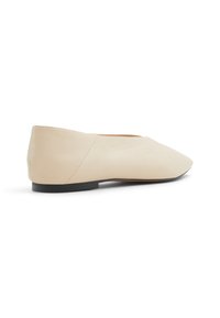 Beige kožené ploché boty s špičatou špičkou, mírným podpatkem a hladkým povrchem. Vyznačují se čistým designem s minimálním zdobením.