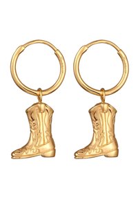 Boucles d'oreilles en métal doré en forme de créoles, ornées de petits pendentifs en forme de bottes de cowboy avec des gravures détaillées et une surface texturée. Le design des bottes est tridimensionnel.