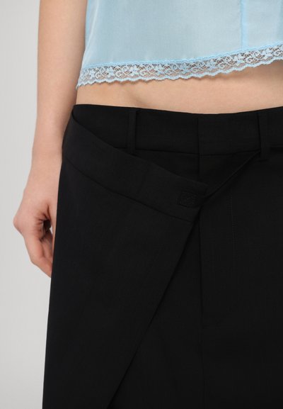 Helles blaues Satinoberteil mit Spitzenbesatz, kombiniert mit maßgeschneiderten schwarzen Hosen mit seitlichem Verschluss und glatter Textur.