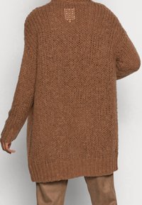 Överdimensionerad brun stickad cardigan med en texturerad väv, med rund halsringning, sänkta axlar och en liten ventildetalj bak.