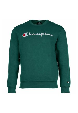 Sudadera verde hecha de una tela suave. Presenta el logo gris "Champion" en el pecho y un parche del logo en la manga izquierda. Cuello redondo.