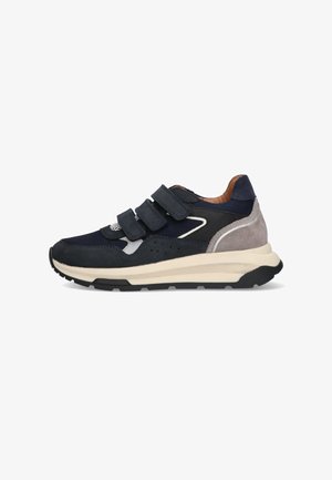 Zapatilla de color azul marino con detalles de malla y ante, tres correas de velcro, suela texturizada y media suela crema. Presenta un diseño elegante y deportivo.