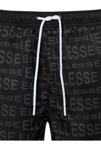 Bañador negro con un patrón de logo "ELLESSE" en un tono más claro. Cuenta con un cordón blanco de cierre con extremos de plástico. Textura suave.