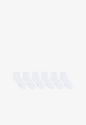 Białe bawełniane skarpetki do kostek, sześć par, o gładkiej fakturze i wzmocnionych mankietach. Każda skarpetka ma subtelne logo marki nadrukowane w pobliżu palców.