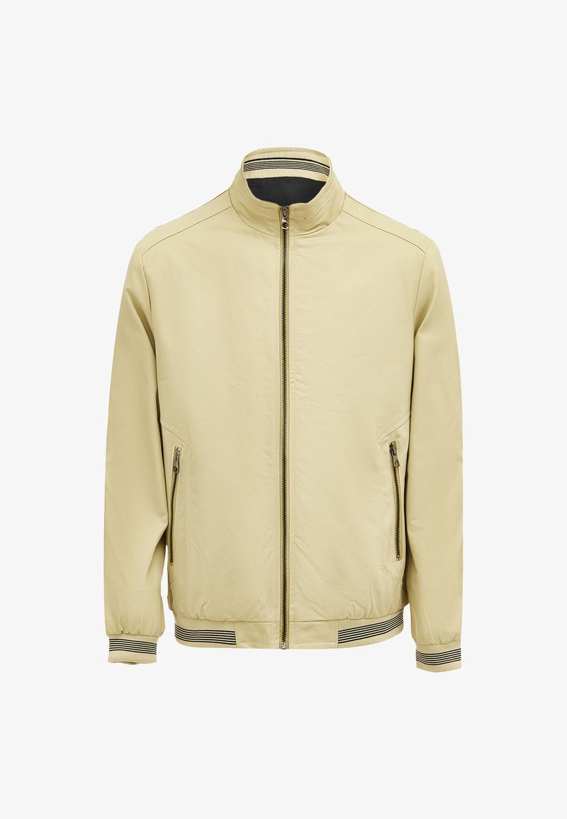 Lichtbeige bomberjack met een staande kraag, full zip, twee zijzakken en gestreepte manchetten. Gladde textuur met een elastische tailleband.