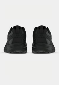 Črne športne čevlje z teksturirano zgornjšo plastjo, ojačanim petnim delom in ravnimi gumijastimi podplati. Preprost dizajn brez vidnih vzorcev ali dodatkov.