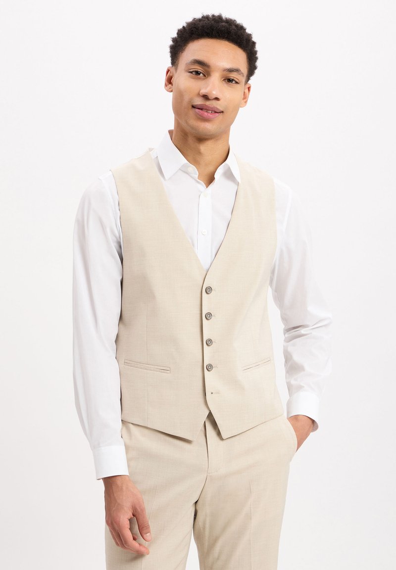 Beige Leinenanzugweste mit fünf Knöpfen, Reverskragen und Seitentaschen, getragen über einem weißen Hemd mit Knöpfen. Glatte Textur und taillierte Passform.