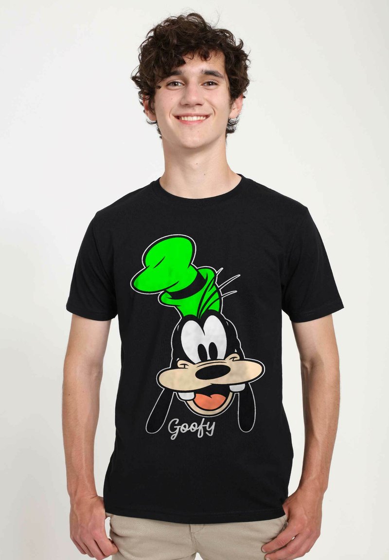 Černé tričko s grafikou karikaturního psa se zeleným kloboukem. Design zahrnuje obličejové rysy a text "Goofy" pod ním.