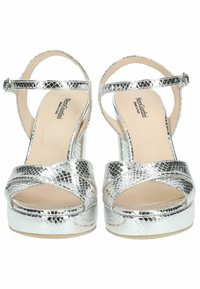 Sandales à talons hauts argentées avec une texture en cuir de serpent, dotées de brides croisées et d'une fermeture à boucle, sur une base en plateforme.