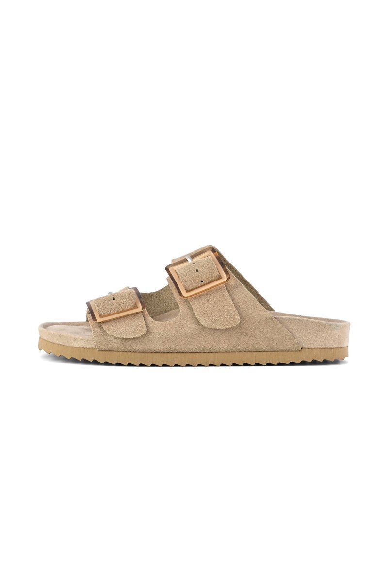 Beige mockaskinn slide sandal med dubbla justerbara spännen, texturerad ovansida och en tjock, mönstrad gummisula för grepp och komfort.