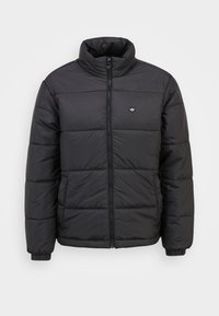 Svart puffjacka med hög krage, dragkedjestängning och elastiska manschetter. Har horisontell quiltad mönster och en liten logotyp på bröstet.