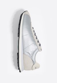Srebrne i beżowe sneakersy z teksturowaną syntetyczną cholewką, zamszowymi detalami, czarną podeszwą i ciemnymi wzorzystymi sznurówkami, pokazane z boku.