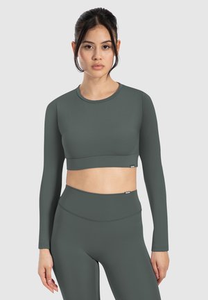 Langärmliges Crop-Top in Dunkelgrün, aus glattem, elastischem Material gefertigt. Hat einen rundem Ausschnitt und eine taillierte Passform. Keine sichtbaren Muster.