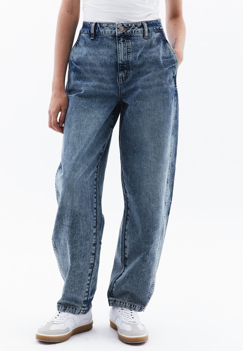 Světle modré džíny s vysokým pasem, volným střihem a širokými nohavicemi, s jemným vyblednutím. Mají klasický design s pěti kapsami a kovovým knoflíkem.