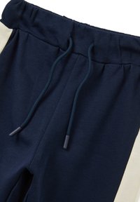 Marineblaue Jogginghosen mit elastischem Bund, passenden Kordeln und einem weißen Seitestreifen.