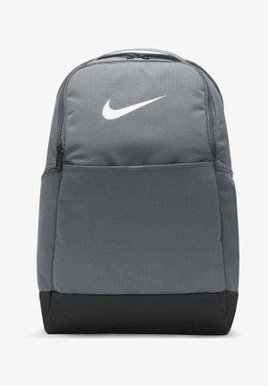 Sivi platneni ruksak s bijelim Nike logotipom, zip-zatvaračem na glavnom odjeljku, mrežastim bočnim džepovima i crnim donjim panelom.