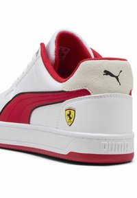 Adidași albi cu accente roșii, având călcâi din piele întoarsă, dungi negre și logo-ul Ferrari. Talpă texturată cu un logo proeminent Puma.
