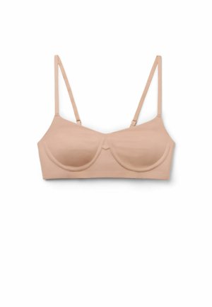 Beżowy, bezszwowy biustonosz z fiszbinami i regulowanymi cienkimi ramiączkami, ułożony na płasko na białym tle.