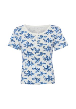 Haut blanc à manches courtes côtelé avec encolure ronde, petits boutons sur le devant et imprimé floral bleu sur l'ensemble.