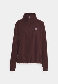 Mörkröd fleecepulli med halv dragkedja, hög krage och elastisk midja. Har raglanärmar och en liten vit Adidas-logga på bröstet.