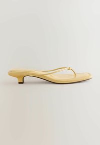 Infradito giallo con un design elegante, caratterizzato da una sottile cinghia, punta affusolata e un tacco basso per un maggiore supporto.