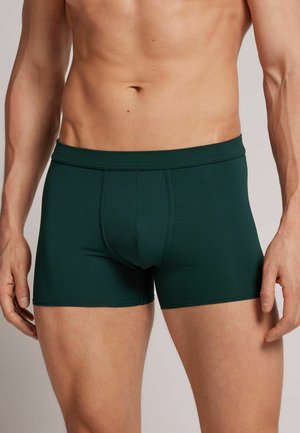 Dunkelgrüne Herren-Boxershorts aus glattem, dehnbarem Stoff mit einer körpernahe Passform. Sie verfügen über einen breiten elastischen Bund und eine Vordernaht.