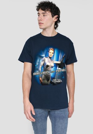 Navyblaue Baumwoll-T-Shirt mit einem grafischen Druck eines Charakters in einem silbernen Anzug, beschriftet mit "Seven of Nine" aus Star Trek: Voyager.