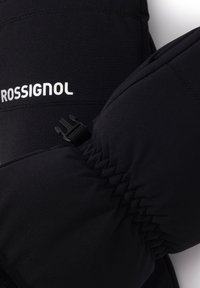 Czarne rękawice narciarskie z elastycznymi mankietami, teksturowanym materiałem i białym logo Rossignol. Posiadają zamek błyskawiczny zapewniający pewne dopasowanie.