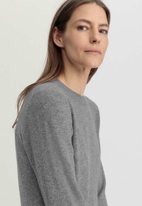 Maglione grigio con scollatura rotonda, realizzato in tessuto morbido e testurizzato. Caratterizzato da maniche lunghe e una vestibilità rilassata, con dettagli di cucitura discreti.