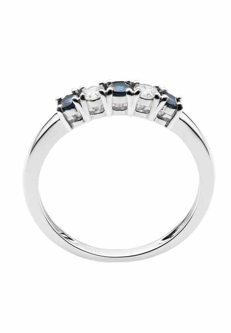 Srebrny pierścionek zdobiony trzema owalnymi niebieskimi kamieniami, na przemian z dwoma przezroczystymi kamieniami, osadzonymi w pazurach, z gładkim, polerowanym pierścieniem.