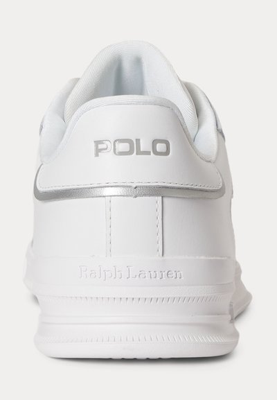 Άσπρο αθλητικό παπούτσι Ralph Lauren, σε προβολή από πίσω, με ασημένιο κείμενο "POLO" και ανάγλυφη επιγραφή "Ralph Lauren" στη σόλα.