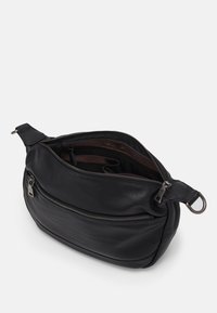 Sac en cuir noir en bandoulière de forme arrondie, avec une fermeture éclair supérieure et une poche zippée à l'avant. Texture lisse et quincaillerie en argent.