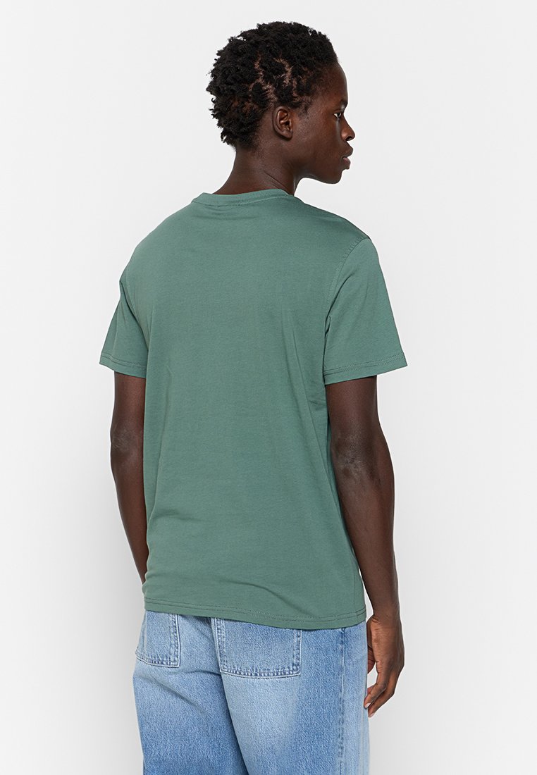 Korte mouwen t-shirt in donkergroen katoen. Ronde hals, rechte snit. Achteraan is de gladde textuur zichtbaar zonder zichtbare patronen of logo's.