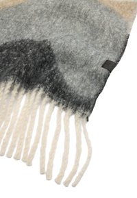 Wełniany szal z gradientem odcieni szarości i beżu, z kremowymi frędzlami na brzegach. Miękka tekstura o gładkim wykończeniu i minimalistyczne logo.