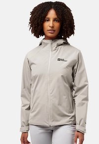 Lichtgrijze waterdichte jas met capuchon, ritssluiting en logo op de borst; gladde textuur en nauwsluitend ontwerp.