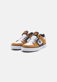 DC skate topánky kombinujúce oranžovú, čiernu a bielu farbu, s vrchnou časťou z oceľovej a koženej vrstvy, plochými šnúrkami a bielou gumovou podrážkou.