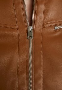 Brun læderjakke med detaljer som en central metallynlås, falske lommer, glat tekstur og synlige syninger.