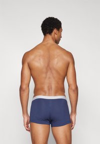 Marineblaues Boxershorts mit einem grauen Bund, aus weichem Stoff gefertigt, mit einer enganliegenden Passform und minimalistischem Design. Rückansicht gezeigt.