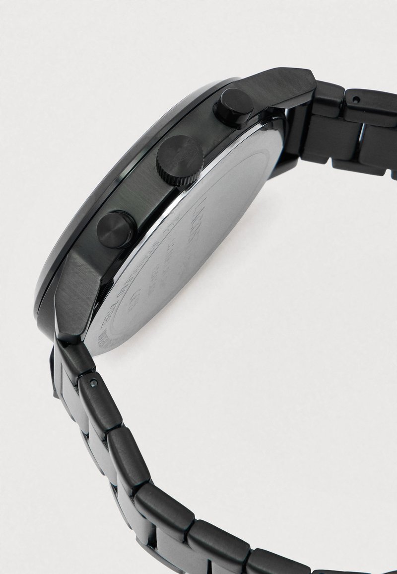 Zwart metalen polshorloge met een schakelsband, met een ronde kast en drie zijknoppen, gefotografeerd tegen een effen lichte achtergrond.