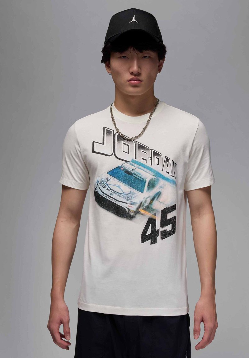 Camiseta de algodón blanca con un gráfico de un coche de carreras blanco, el texto "JORDAN" en negrita negra y el número "45" en una gran fuente negra.