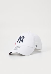Gorra de algodón blanca con el logotipo "NY" bordado en azul marino, visera curva y acento rojo. Presenta una etiqueta de marca en el frente y el lado.