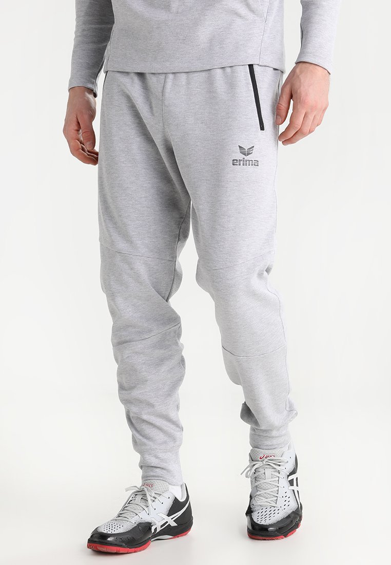 Graue Sweatpants aus weichem Stoff, mit schmaler Passform, zulaufenden Beinen, Reißverschlusstaschen und einem Logo in der Nähe des Bundes.