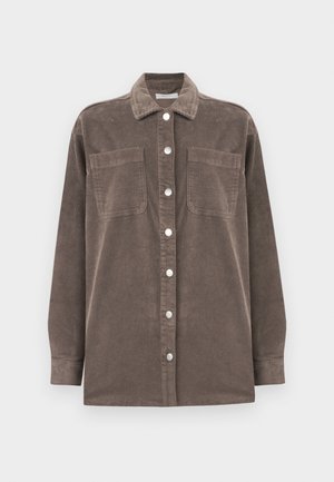 Chemise en velours côtelé marron avec un col, fermeture à boutons sur le devant, et deux poches poitrine. Dotée de manches longues et d'un design en tissu texturé.
