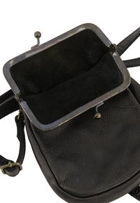 Sac en cuir noir en bandoulière avec une surface texturée, une fermeture métallique et un intérieur doublé en daim avec un fond plat et une sangle ajustable.