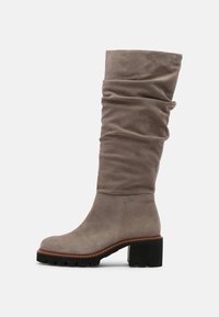 Bota de ante taupe hasta la rodilla con caña arrugada, tacón cuadrado, punta redonda y suela de gomma negra sobre fondo blanco.